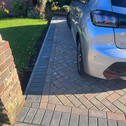 greyish red brick lined with grey brick - silver car bumper on right close
